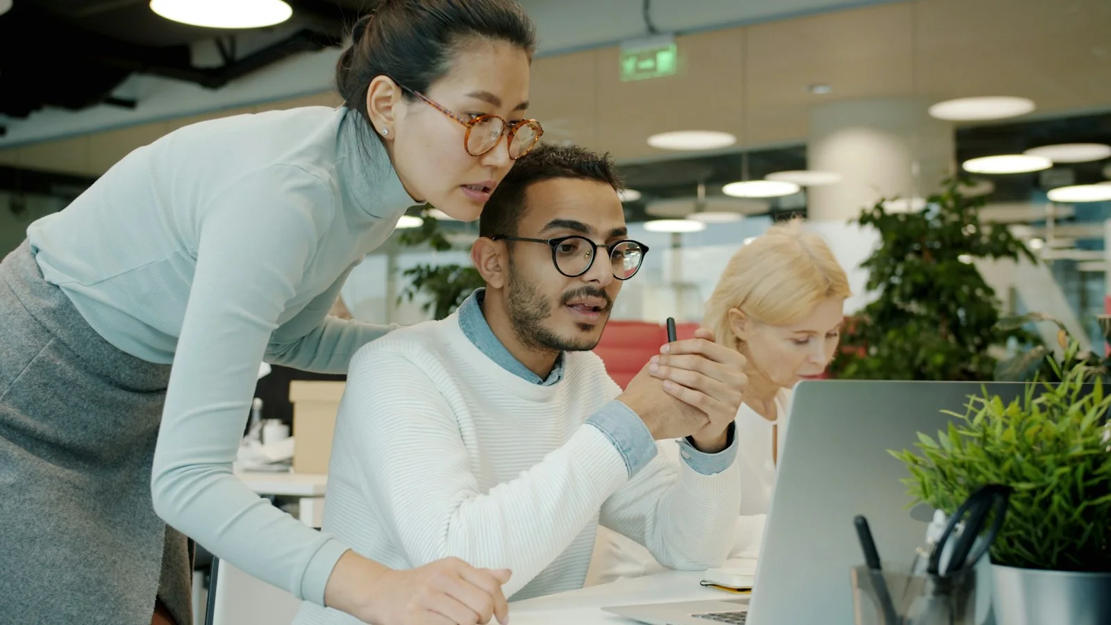 Two colleagues working together at a computer in a shared office